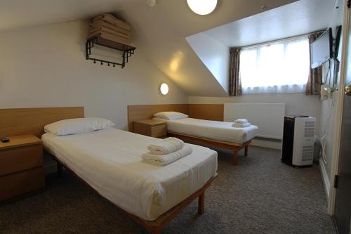 伦敦贵族酒店的酒店客房设有两张床和窗户。