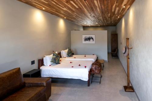 卡萨内Chobe River Lodge的一间卧室配有一张大床和一张沙发