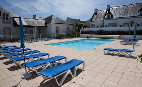 洛克马里亚Retour de plage的一组蓝色的躺椅和一个游泳池