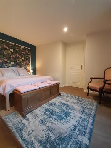 马泽内姆Les Cottages du Chateau de Werde的一间卧室配有一张大床和蓝色地毯。