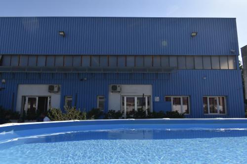 阿莱齐奥Ostello Salento的蓝色的建筑,前面设有一个游泳池