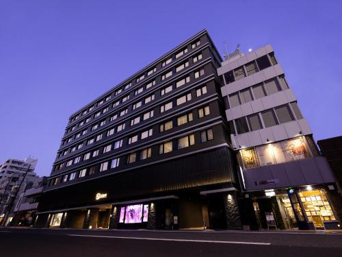 京都La'gent Hotel Kyoto Nijo的一条城市街道上高大的黑色建筑