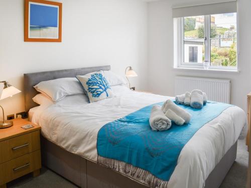 法尔茅斯Puffling的一间卧室配有一张大床和毛巾
