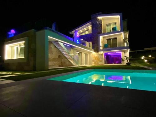 皮佐Villa Rocca - Rooms&SPA的一座晚上设有游泳池的房子