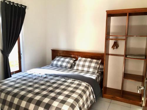 NdanguLOPE HOMESTAY的一间卧室设有一张床和一个书架