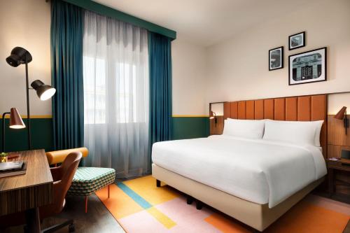 米兰Duo Milan Porta Nuova, a Tribute Portfolio Hotel的酒店客房配有一张床、一张书桌和一张书桌。