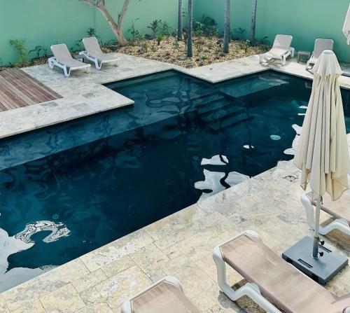 圣吉尔莱班热带公寓酒店的一个带蓝色水和两把椅子的游泳池