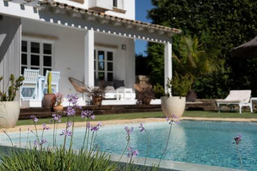 贝赫尔-德拉弗龙特拉卡萨拉西埃斯特酒店的一座带游泳池和紫色鲜花的房子