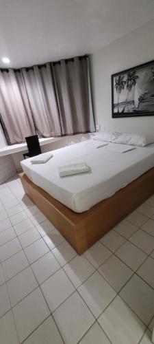 若昂佩索阿Hotel Victory Business Flat Beira Mar Tambaú的一间卧室,卧室内配有一张大床