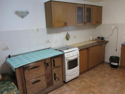 科巴里德Apartma Vilma的厨房配有木制橱柜和白色炉灶烤箱。