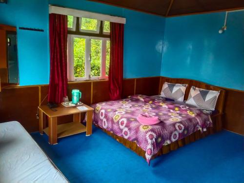 拉瓦格拉The Himalayan Resort的一间卧室配有一张床、一张桌子和一个窗户。
