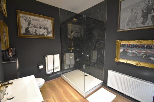 斯帕Luxury Spa Hotel - Automobile的浴室设有白色卫生间和黑色墙壁。