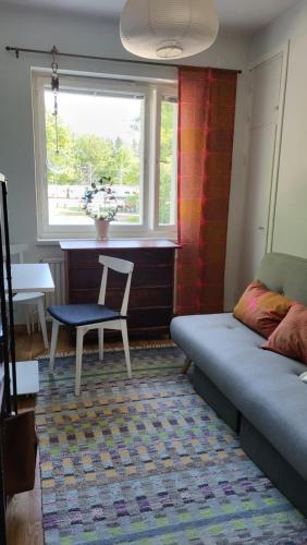 海门林纳Peaceful and beautiful apartment in Hämeenlinna的客厅配有床、椅子和窗户