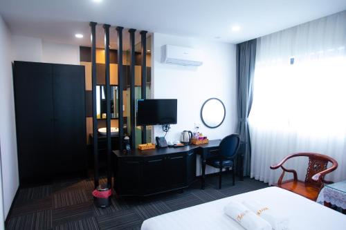 永隆ONE HOTEL的酒店客房配有一张床和一张书桌及一台电视