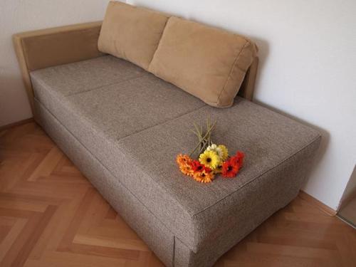 图彻皮Apartments Mira的一张棕色的沙发,上面有花束