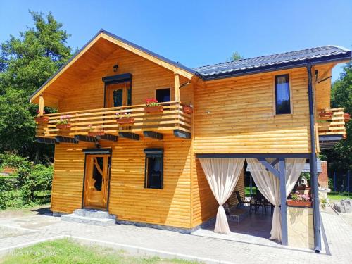 阿夫里格ART House Transylvania , Valea Avrigului , Sibiu的带阳台和门廊的木屋