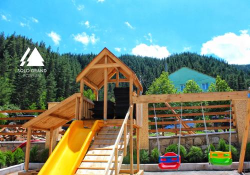 Solo Grand Boshuri Hotel Wellness Resort的木游戏结构,带滑梯和游乐场