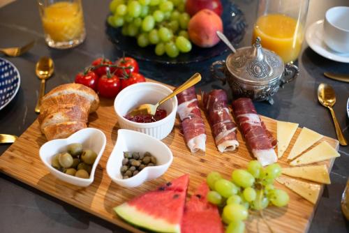 锡尼Apartments Allegra的桌上的盘子,包括肉和水果