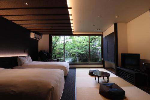 姬路Yumoto Ueyama Ryokan的酒店客房设有两张床和电视。
