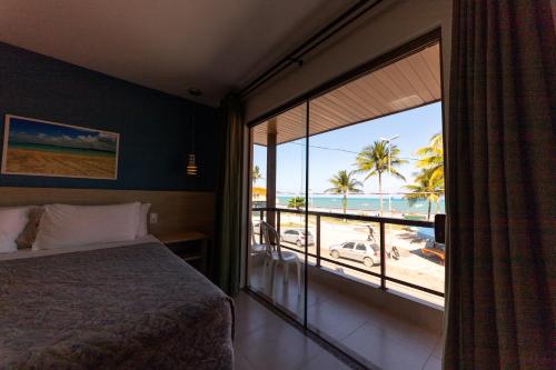 马拉戈日 马里卢斯包萨达旅馆的一间卧室配有一张床,享有海滩美景