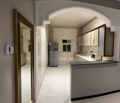 Sūq al Aḩadفندق وايت هافن的带冰箱和柜台的大厨房