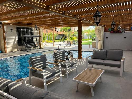 杰里科فلل ليليان الحديثة的一个带沙发和椅子的庭院和一个游泳池