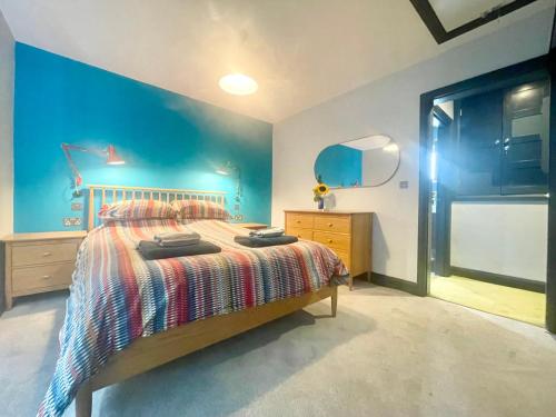 锡豪西斯Farne Island Bed and Breakfast的一间卧室设有一张床和蓝色的墙壁