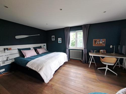那慕尔Sherlock's Home - Guest House的一间卧室配有一张大床、一张桌子和一张书桌