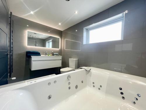 锡豪西斯Farne Island Bed and Breakfast的浴室配有大型白色浴缸和水槽