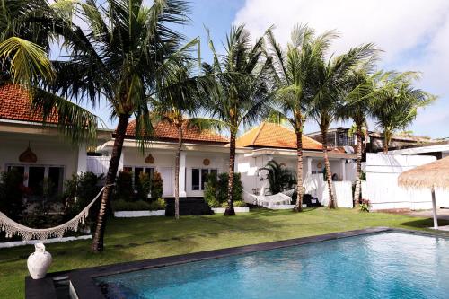 乌鲁瓦图Bella Bali的一座带游泳池和棕榈树的房子