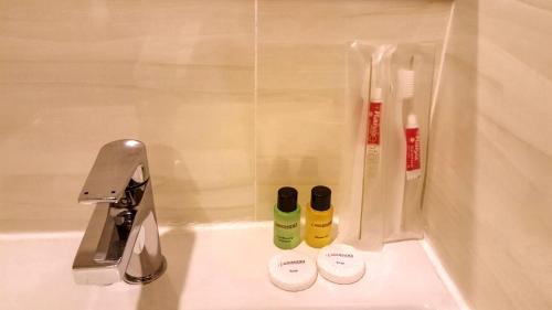 努沙再也Crescendo Boutique Hotel的浴室水槽配有两瓶牙刷和水龙头