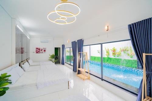 头顿Lee Phương Villa - Free Karaoke - Bida - Gần Bãi Sau的客厅设有大窗户和游泳池