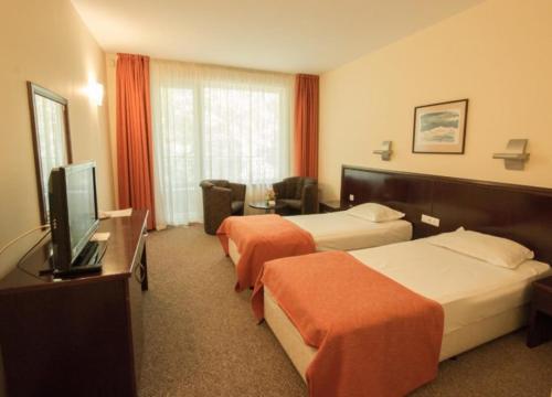 瓦尔纳Hotel Divesta - self check in的酒店客房设有两张床和一台平面电视。