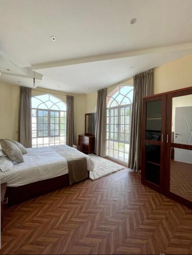 马斯喀特Deluxe Apartment的一间卧室设有一张床和两个窗户。