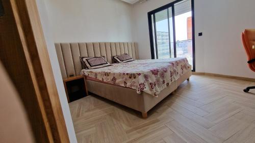 莫纳斯提尔Lovely apartment in Monastir的一间卧室设有一张床和一个大窗户