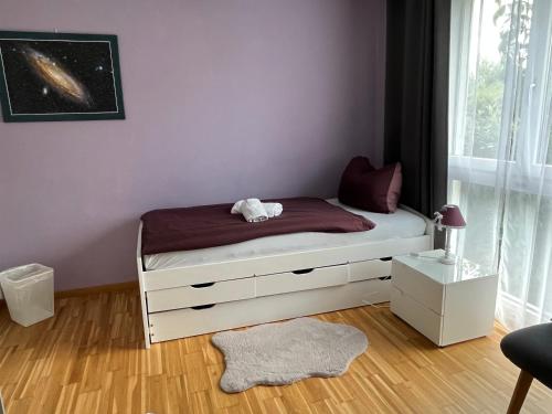 克罗伊茨林根Oasi 2的一间卧室配有一张紫色墙壁的床