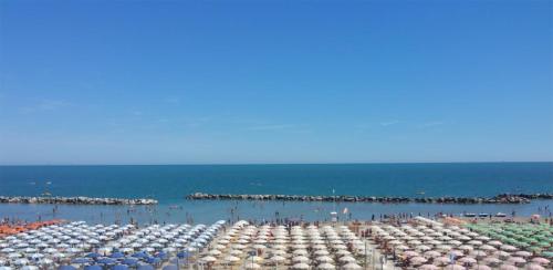 里米尼Hotel Villa Mon Reve的海滩上的一组遮阳伞