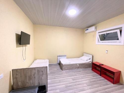 塔什干Stay hostel的一间设有两张床和一台电视的房间