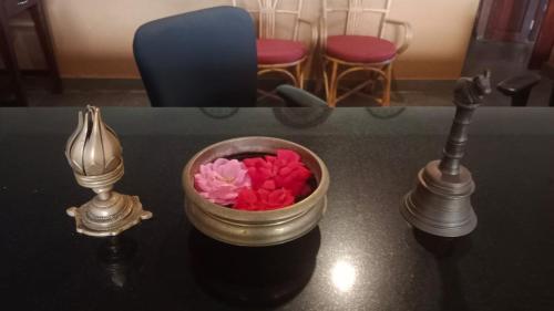 圣弗拉斯Медицински Център Аюрведа的一张桌子,上面放着一碗鲜花和两盏灯