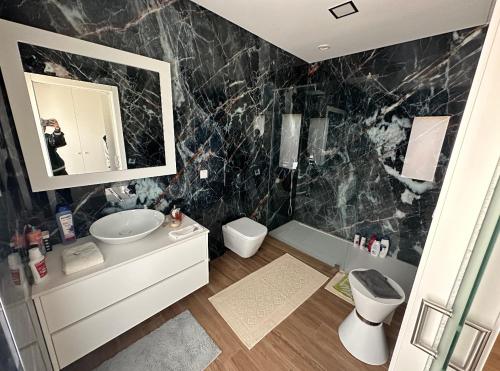 埃里塞拉Ericeira Luxury的黑色大理石浴室设有水槽和镜子