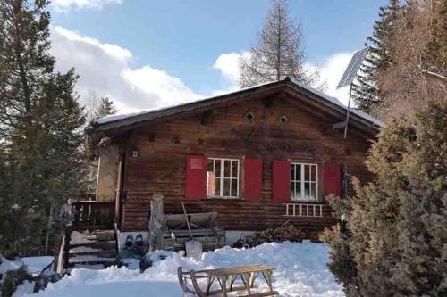 Beautiful Swiss chalet with breathtaking views and a sauna的雪中带红色门的小木屋