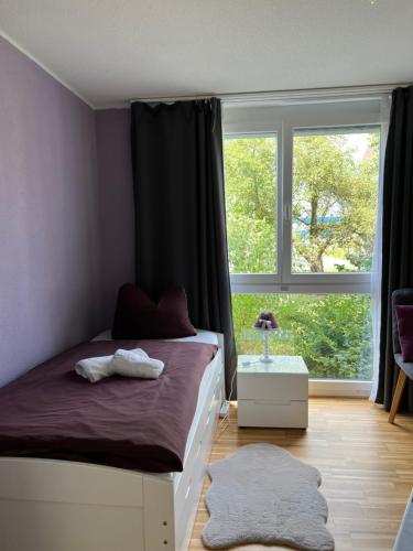 克罗伊茨林根Oasi 2的一间卧室设有一张床和一个大窗户