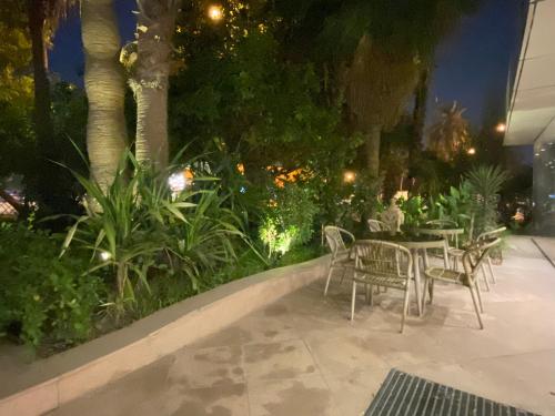 麦纳麦曼苏里公寓式酒店的庭院在晚上配有桌椅和植物
