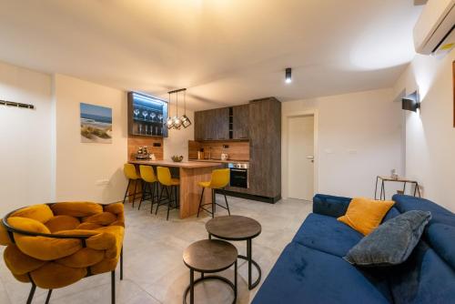 卡斯塔夫Apartman Noa的一间带蓝色沙发的客厅和一间厨房