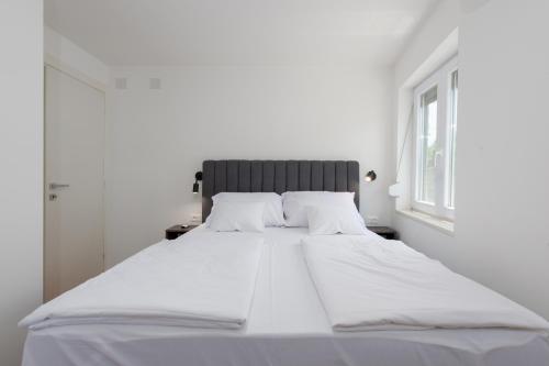 卡斯塔夫Apartman Noa的白色的客房内的一张大白色床,设有窗户