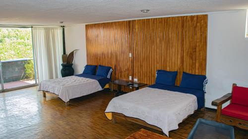 库埃纳瓦卡Suites Las Plazas的一间卧室配有两张床、一张沙发和一张桌子