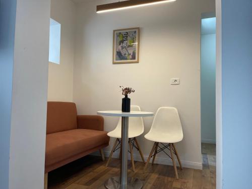 地拉那Central Studio Apartments的配有桌子、两把椅子和一张沙发的房间