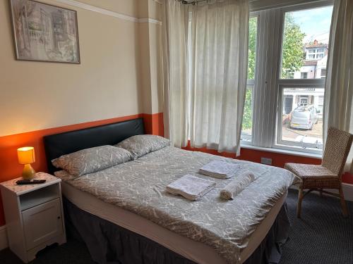 滨海绍森德Malvern Lodge Guest House- Close to Beach, Train Station & Southend Airport的一间卧室配有带2条毛巾的床和窗户。