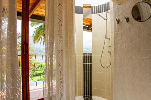 康提三角梅度假别墅的带淋浴的浴室,享有美景。