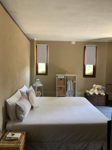 切尔诺比奥Il Riccio appartamento的配有2扇窗户的客房内一张大白床